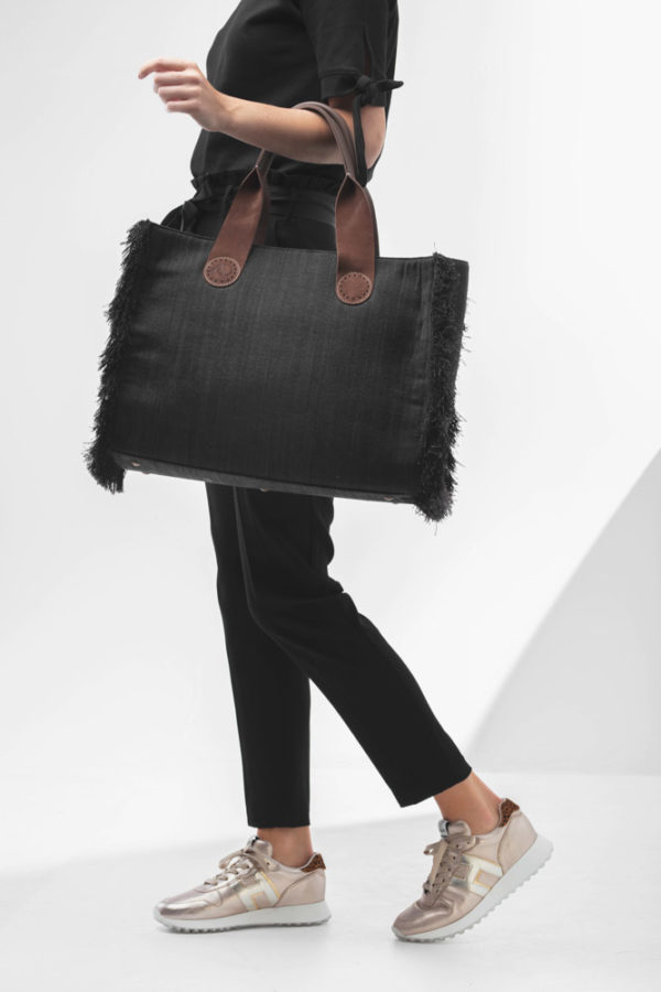 De Belle Large in Black Jeans staat stijlvol en vrouwelijk bij een zwarte outfit.